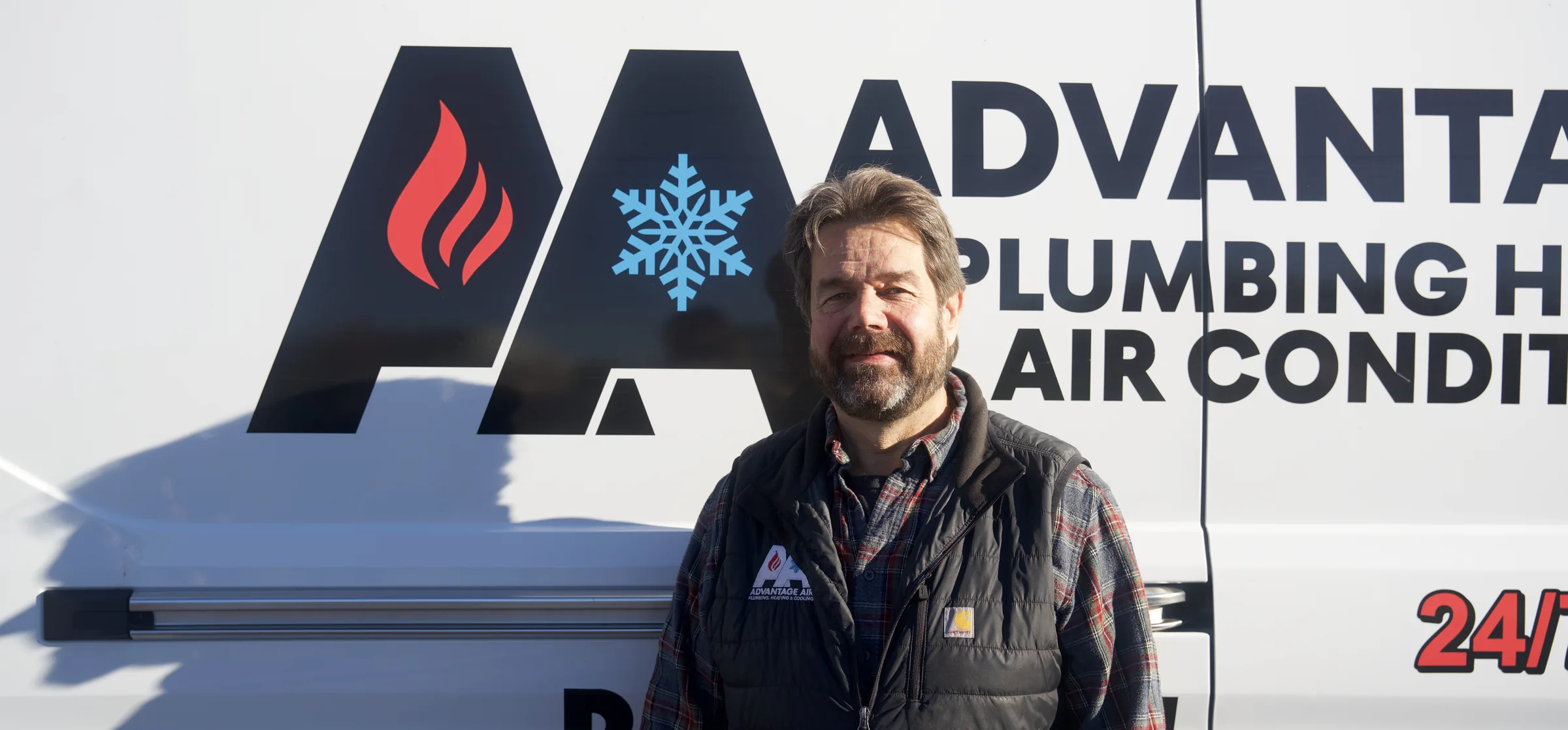 Joe Ligman, owner of Advantage Air, beside a company van on Tower Avenue, Superior